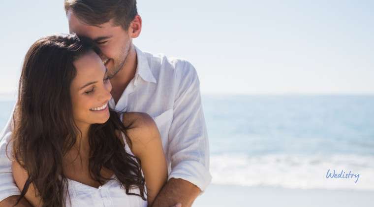 Happy couple embracing on beach in romantic wedding photos, perfect for wedding inspiration and planning.