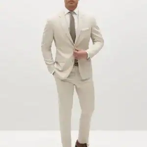 Classic beige groom suit with brown shoes for wedding or formal event, contemporary men's fashion.