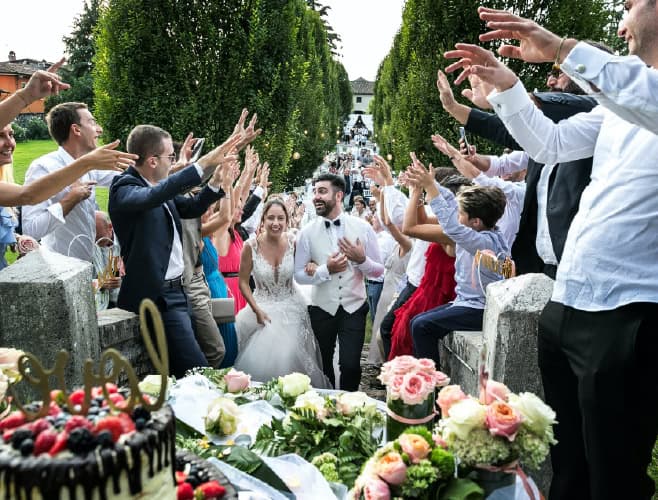 Joyful wedding celebration with bride and groom surrounded by friends and family outdoors.