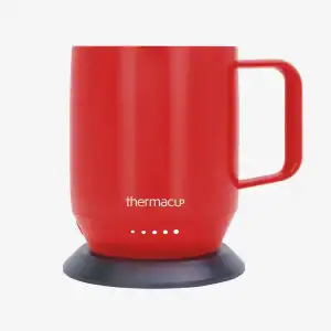 Portable red thermal mug with black silicone base and handle for everyday use.
