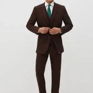 Elegant groom in dark brown suit with teal tie for wedding attire.