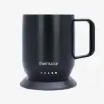 Black ThermoCup coffee mug with smart heating base for optimal temperature control.