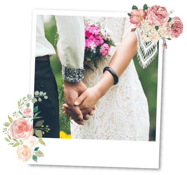 Romantic couple holding hands at wedding ceremony with floral decorations.